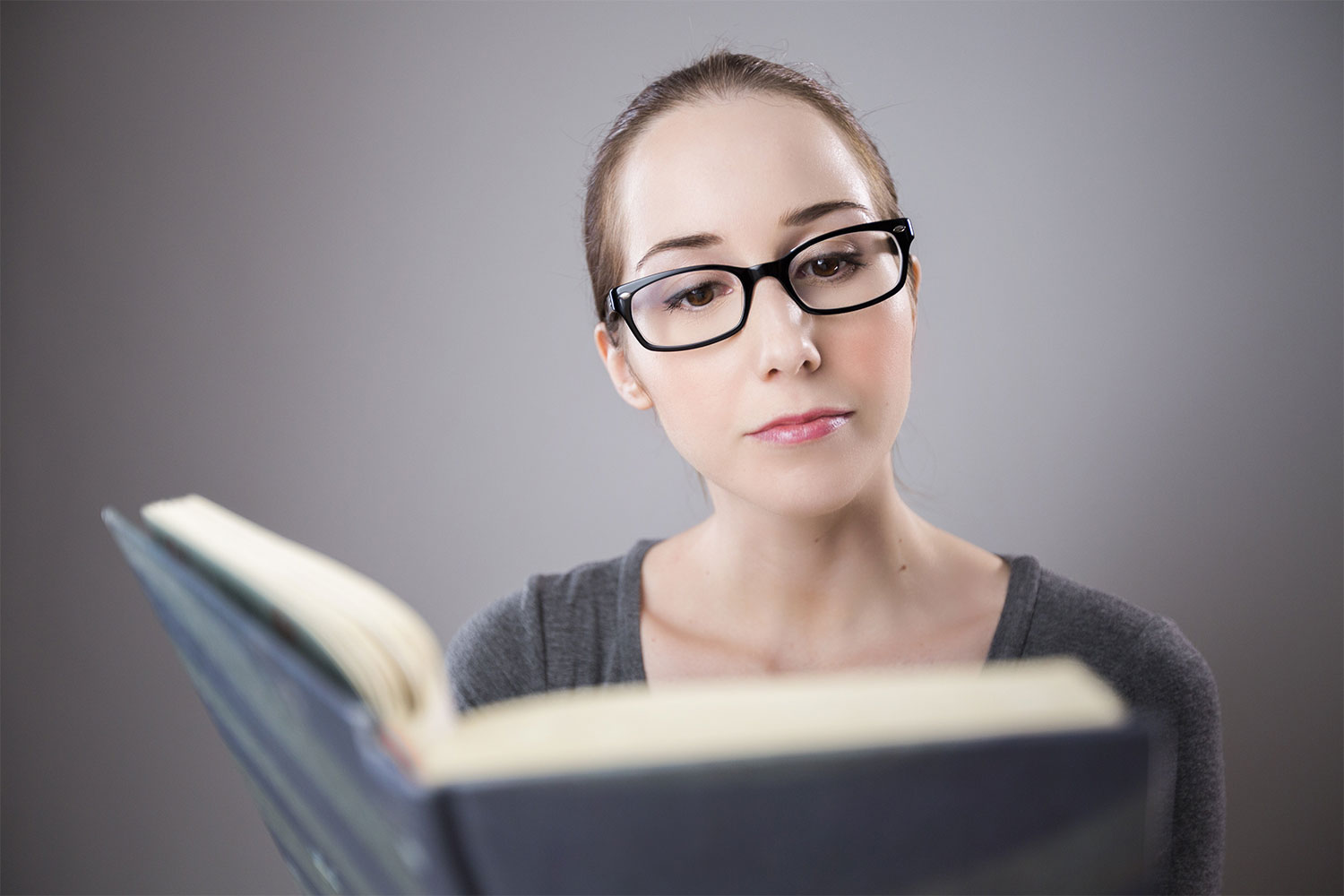 Student reading a book while studying