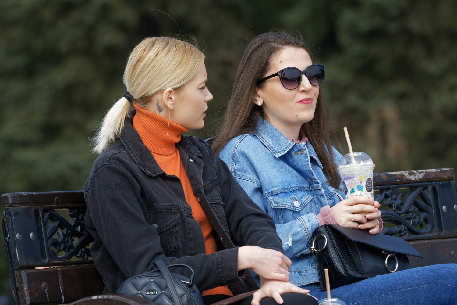 Two people sitting together on a bench in conversation