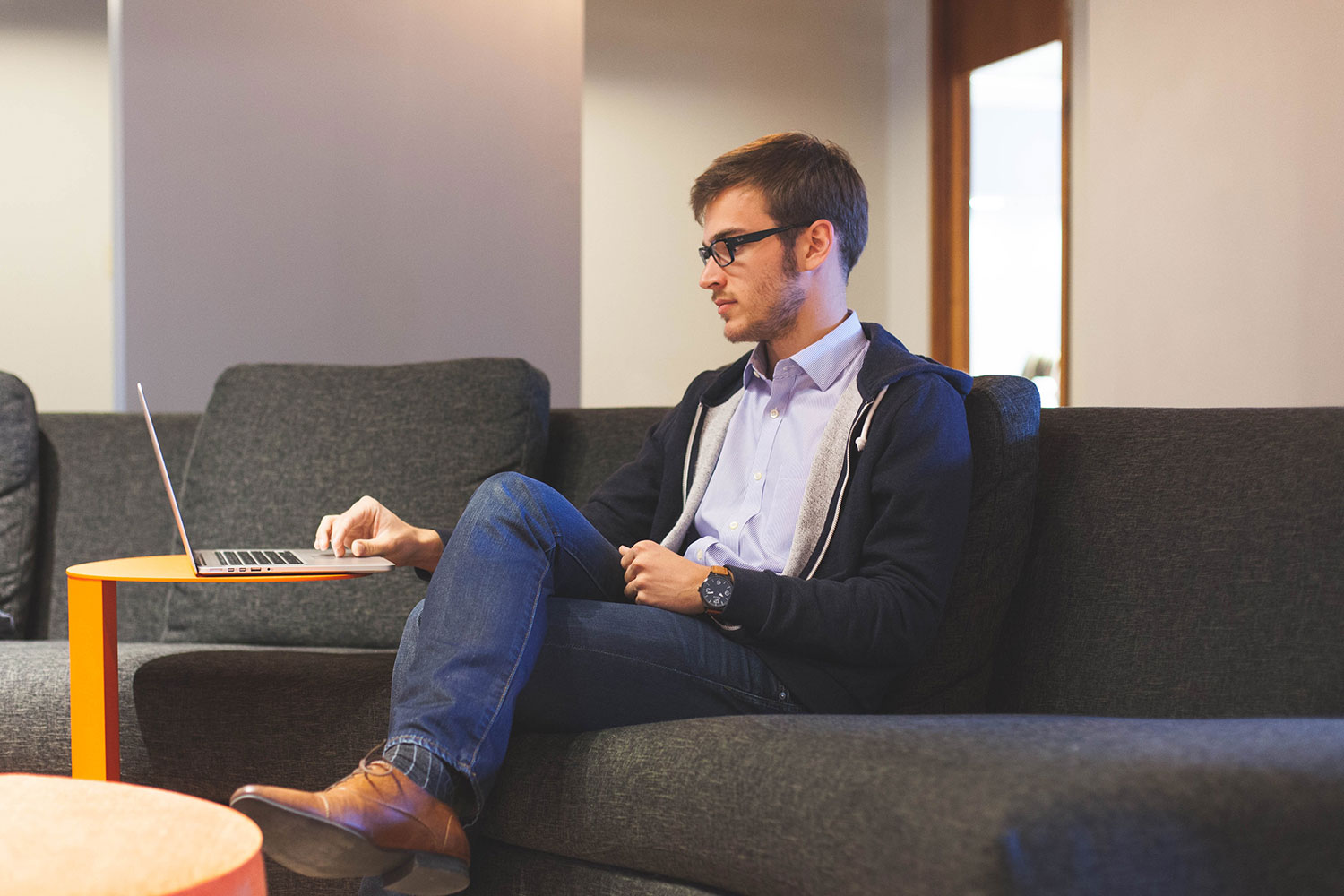 Student entrepreneur working on a laptop from a sofa